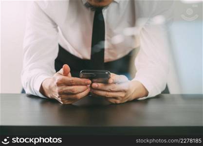 close up of businessman working with mobile phone on wooden desk in modern office with virtual icon diagram with glass reflected view