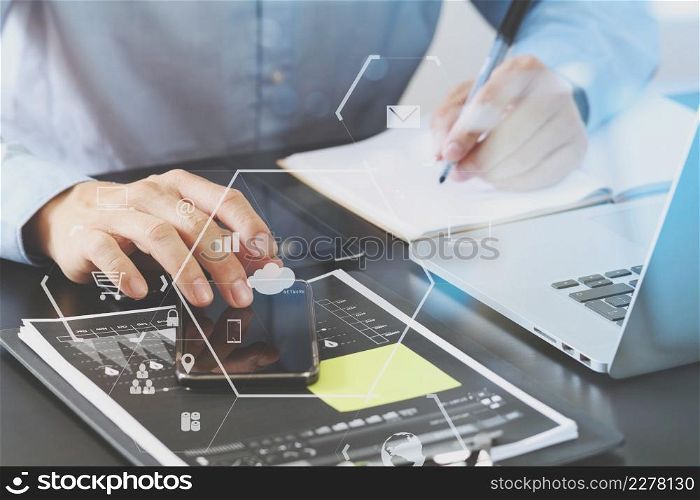 close up of businessman working with smart phone and digital tablet and laptop computer on wooden desk in modern office with London city exposure
