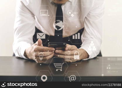 close up of businessman working with smart phone on wooden desk in modern office with virtual icon diagram