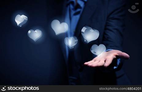 Close up of businesswoman hand holding digital icon in palm. Heart glass icons in palm