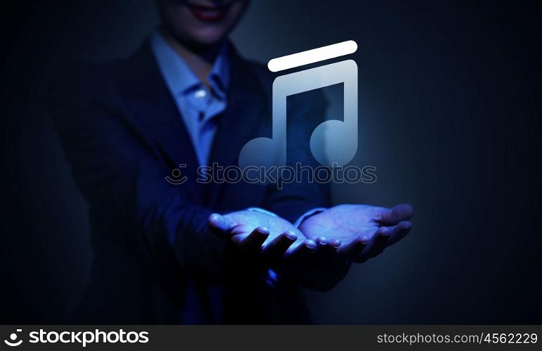 Close up of businesswoman hand holding digital icon in palm. Music application icon