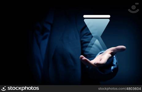Close up of businesswoman hand holding digital icon in palm. Sandglass icon in palms