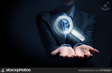 Close up of businesswoman hand holding digital icon in palm. Search icon in palm