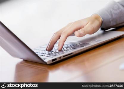 Close up of businesswoman hands using laptop at office desk