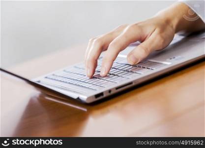 Close up of businesswoman hands using laptop at office desk
