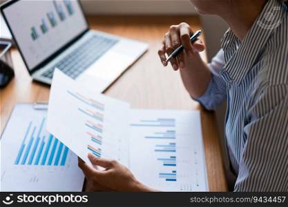 Close up of businesswoman is thinking strategy while reading data on laptop and business document.