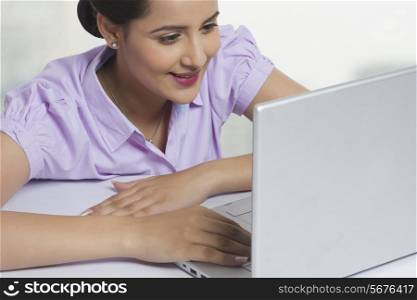 Close-up of businesswoman using laptop at office desk