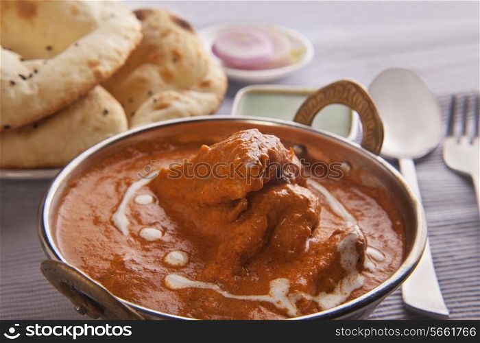 Close-up of butter chicken garnished with cream