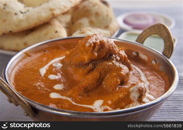 Close-up of butter chicken with tandoori rotis