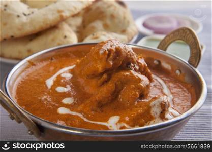 Close-up of butter chicken with tandoori rotis