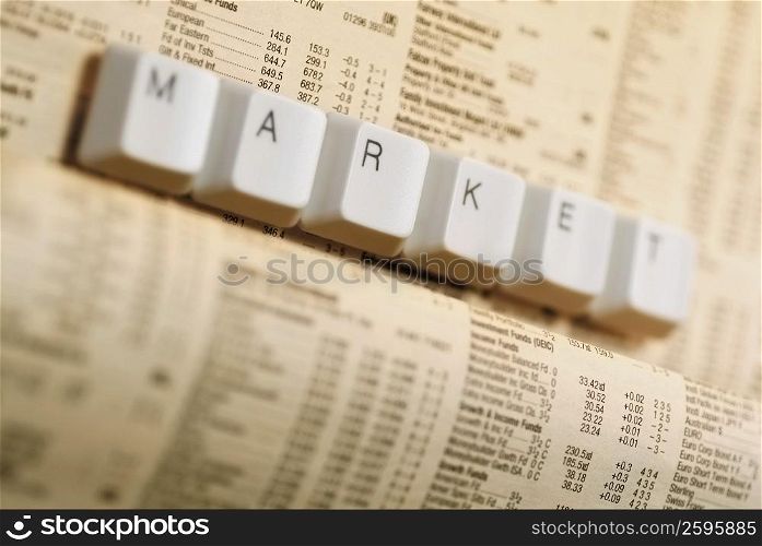 Close-up of buttons of computer keyboard on a financial newspaper