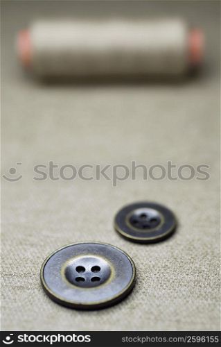 Close-up of buttons with a spool of thread