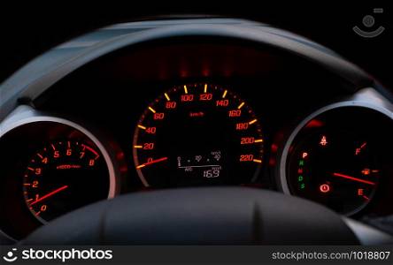 Close up of car speedometer with the needle pointing at 0 kmp on black blackground