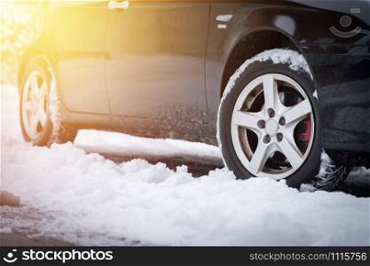 Close up of car tire covered with snow on a slippery road
