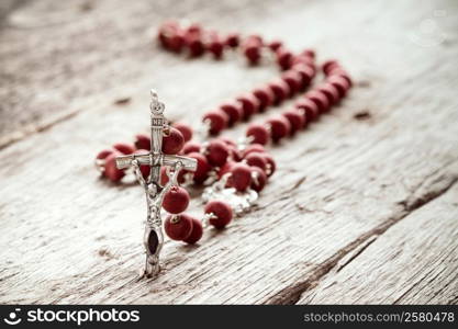 Close-up of catholic rosary on old wooden texture background