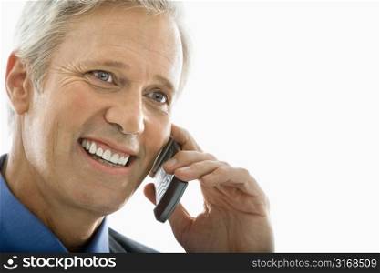 Close up of Caucasian middle aged man smiling and talking on cell phone.