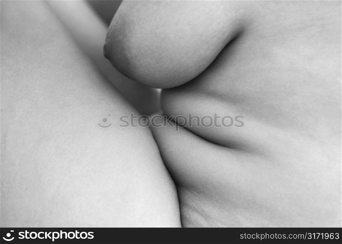 Close up of Caucasian young adult female nude body sitting.
