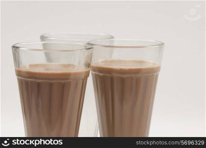 Close-up of chai glasses with an empty glass isolated over white background