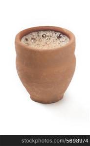 Close-up of chai in traditional cup made of mud isolated over white background