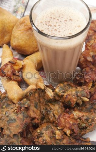 Close-up of chai with pakoras , bhajiyas and fried potato balls