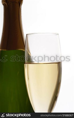 Close-up of champagne in a champagne flute with a champagne bottle
