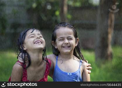 Close-up of cheerful girls enjoying in rain