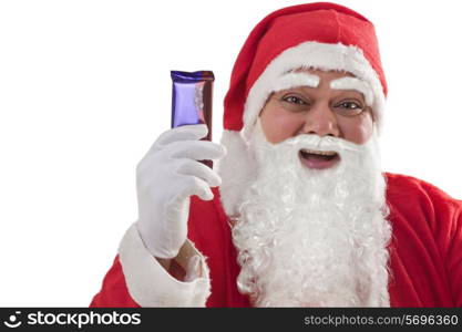 Close-up of cheerful Santa Claus showing chocolate over white background