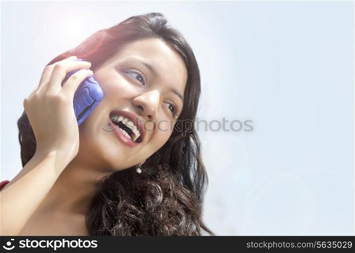 Close-up of cheerful woman having conversation on mobile phone