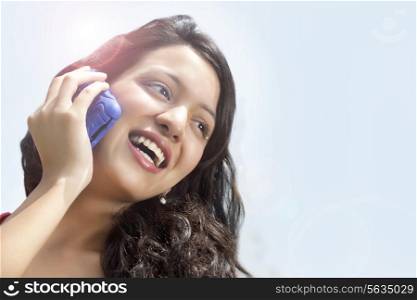 Close-up of cheerful woman having conversation on mobile phone