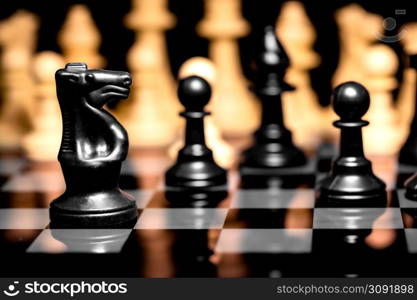 Close up of Chess pieces on a reflective mirror board surface with a plain black background