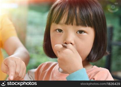 Close-up of Child girl eating ice cream in outdoor cafe. Selective focus