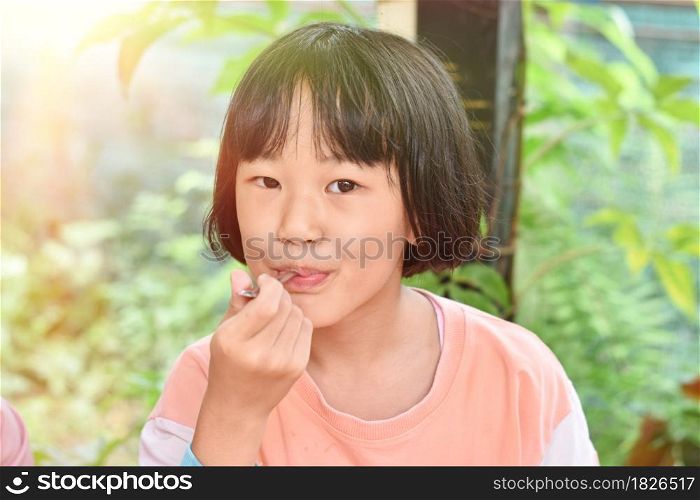 Close-up of Child girl hands holding spoon eating ice cream. Selective focus
