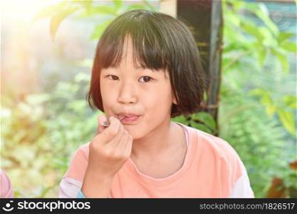 Close-up of Child girl hands holding spoon eating ice cream. Selective focus