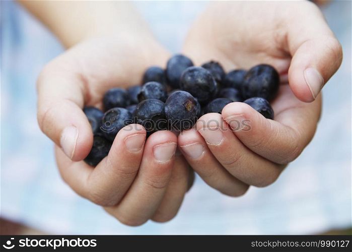 Close Up Of Child Holding Fresh Blueberries