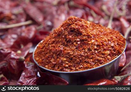 Close up of chilli powder in bowl and red chillies