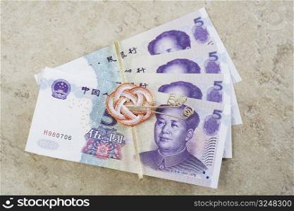 Close-up of Chinese currency tied with a ribbon