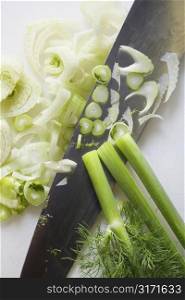 Close up of chopped fennel with large kitchen knife.