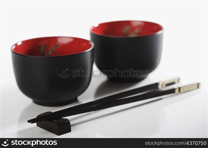 Close-up of chopsticks with two bowls