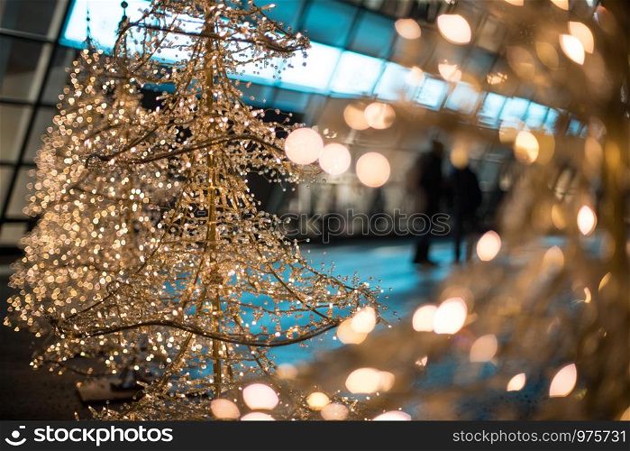 Close up of Christmas decoration lighting in front of a shopping mall, defocused