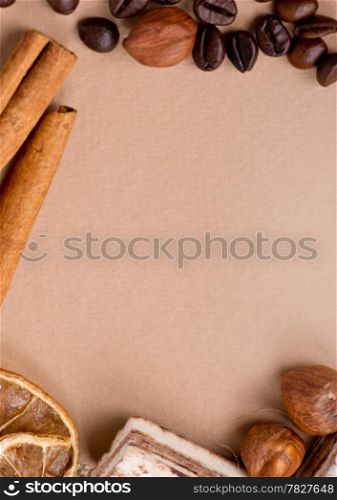 Close up of coffee, cinnamon, nuts, sweet on old paper material. Place for text.