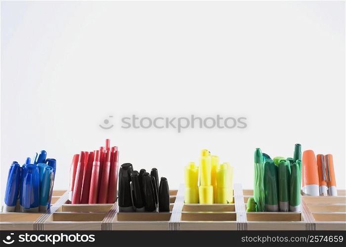 Close-up of colored pens in pen stands