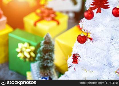 Close up of Colorful balls on White Christmas tree with gifts background Decoration During Christmas and New Year.