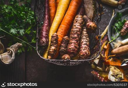 Close up of colorful organic root vegetables in harvest basket on dark background, top view. Healthy and clean food and eating concept.