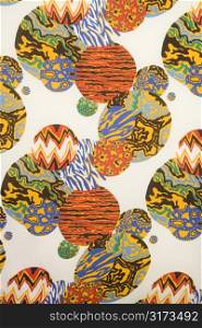 Close-up of colorful vintage fabric with orbs of abstract designs printed on polyester.