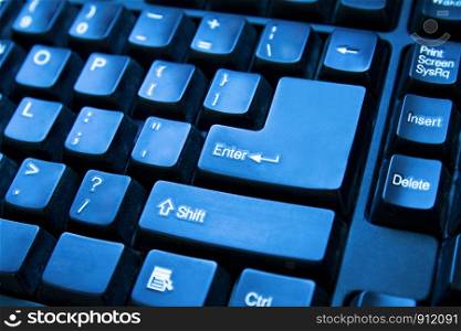 Close-up of computer keyboard. Toned in blue