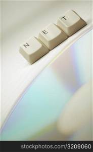 Close-up of computer keys near a CD spelling the word net