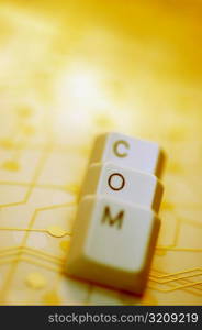 Close-up of computer keys on a circuit board spelling the word com
