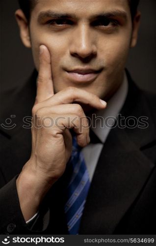 Close-up of confident business man with hand on chin