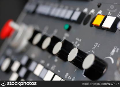 Close up of control panel of CNC machine with adjustment controls and push buttons. Selective focus.