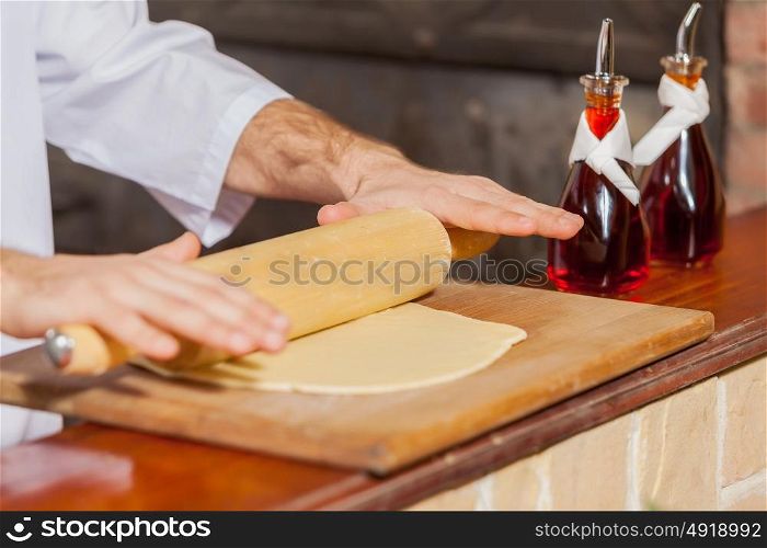 Close-up of cook hands. Close-up image of cook hands rolling out dough